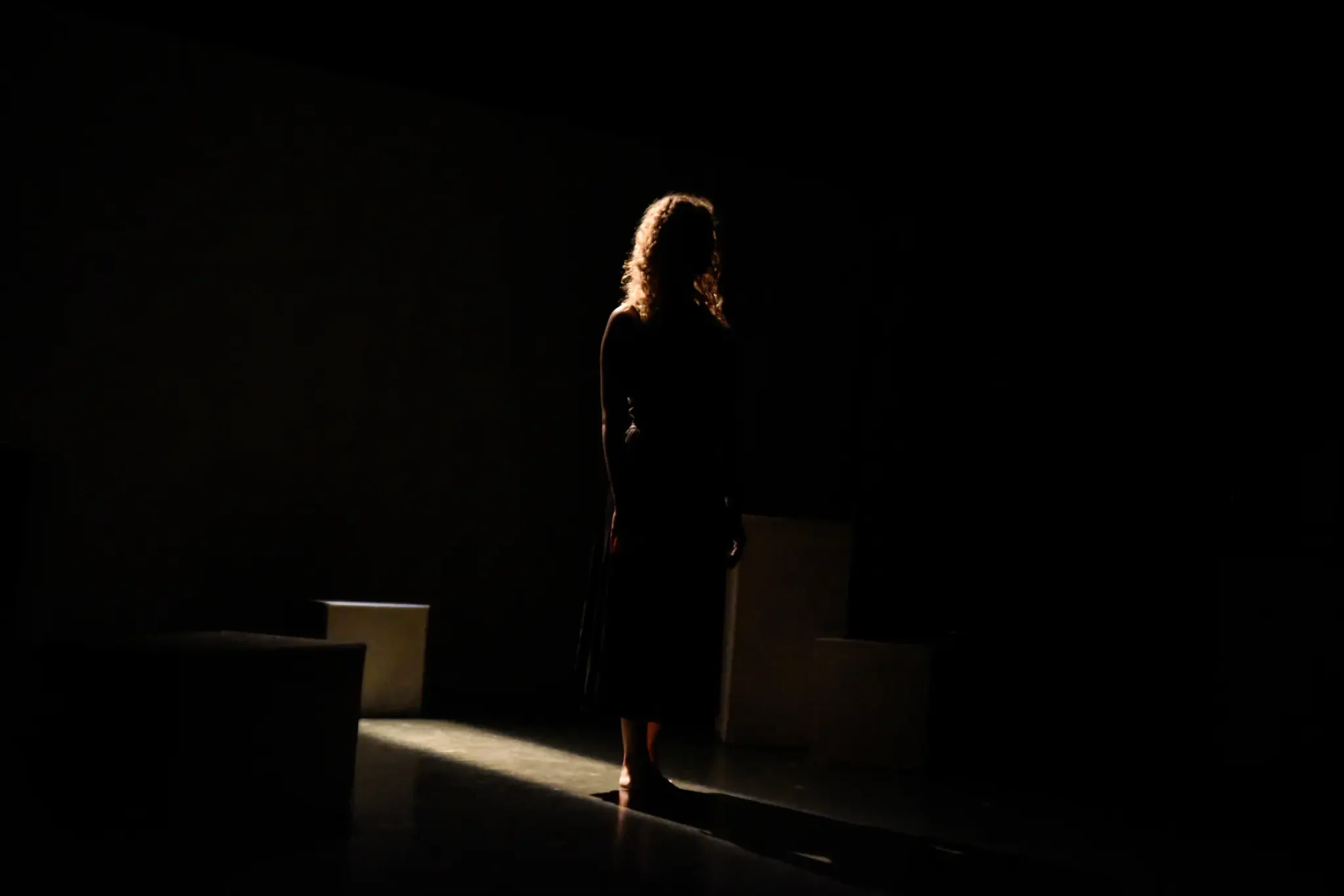 A lone figure on a dark stage